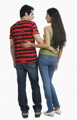 Rear view of a couple standing with arm around