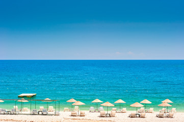 Obraz premium empty beach with white wicker umbrellas