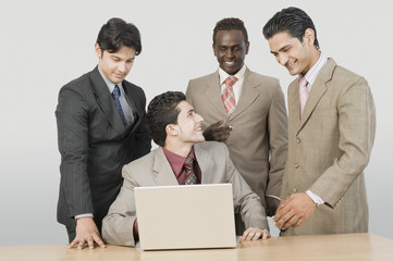 Fototapeta na wymiar Four businessmen in front of a laptop