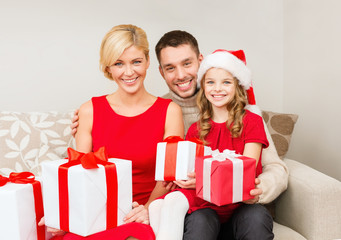 smiling family holding many gift boxes
