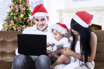 Fototapeta premium Christmas family using a laptop