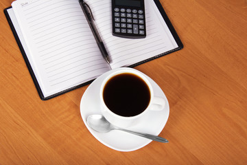 Open notepad and cup of coffee