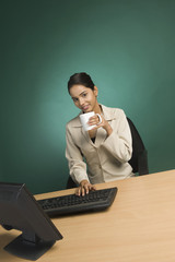Businesswoman working in an office with a cup of coffee