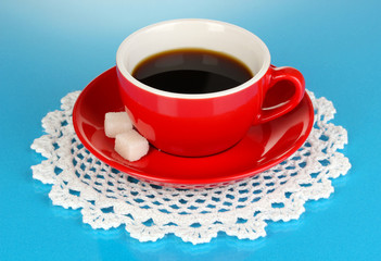 A red cup of strong coffee on blue background