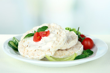 Tasty crispbreads with vegetables on white table