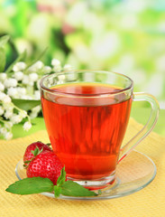 Delicious strawberry tea on table on bright background