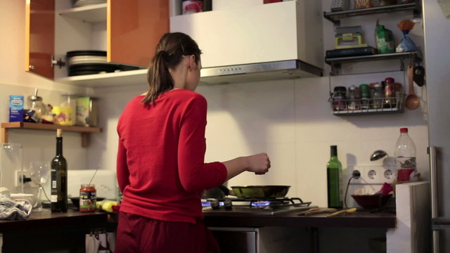 Woman cooking meal in kitchen