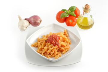 Piatto di pasta fusilli al pomodoro su sfondo bianco