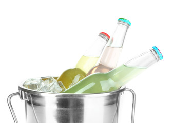 Bottled drinks in ice bucket isolated on white