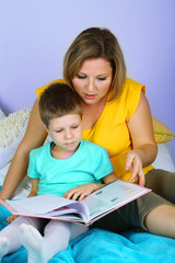 Fototapeta na wymiar Little boy with mom read book in bed