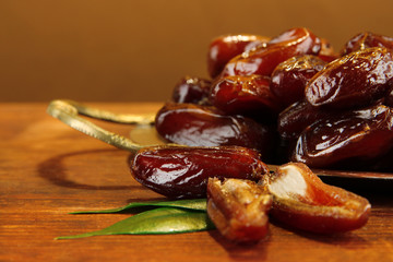Dried dates on metal tray on wooden background