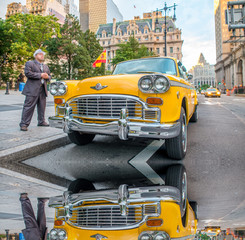 Vintage yellow taxi in New York streets with driver waiting for