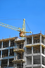Fototapeta premium Crane and building construction site against blue sky