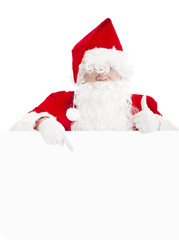 happy Santa Claus pointing at blank banner with thumb up