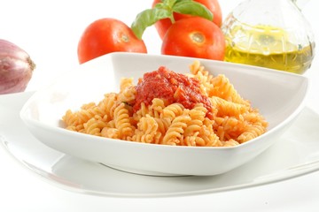 Piatto di pasta fusilli al pomodoro su sfondo bianco