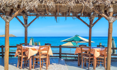Beach cafe with wooden tables and chairs  at the sea