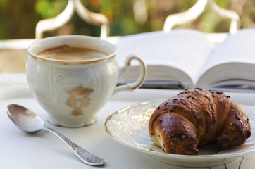 Coffee, croissant and book