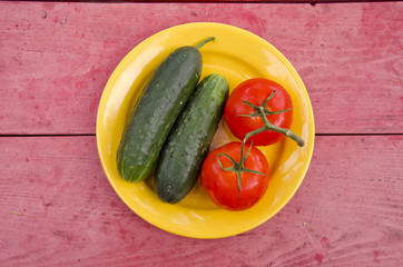 fresh tomato ond cucumber in yellow plate