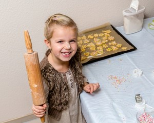 Little girl holding rolling pin  make cookies