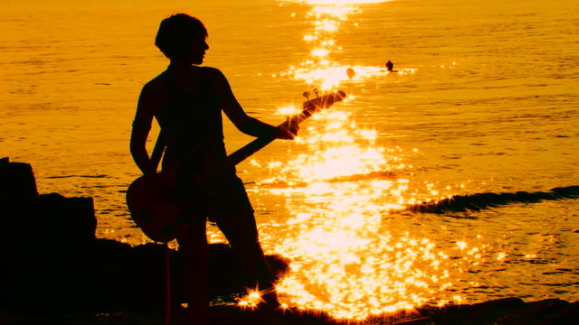 Guitarist playing rock at sunset. Time lapse
