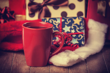 Cup of coffee and gifts at background