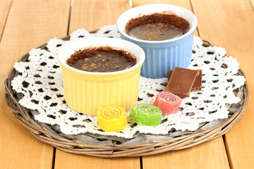 Chocolate pudding in bowls for baking on wooden table