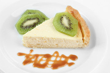 Slice of cheesecake with kiwi fruit and caramel sauce