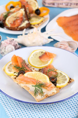 Salmon sandwiches on plate  on wooden table close-up