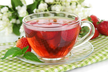 Delicious strawberry tea on table close-up