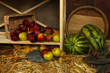 Apples in basket and watermelons on shelf close up
