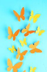 Paper butterflies on blue wooden board background