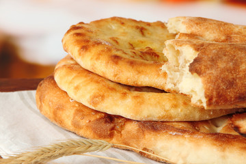 Pita breads with spikes on table on bright background