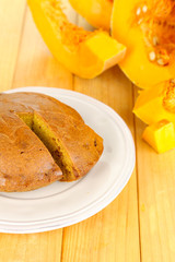 Delicious pumpkin pie on plate on wooden table close-up