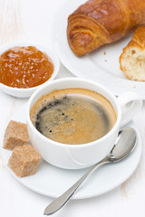 breakfast with black coffee, croissants and orange jam