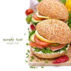 burger with smoked salmon, vegetables and lemon isolated