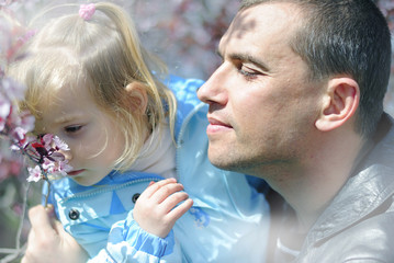 little girl in the spring in the park for a walk with his father