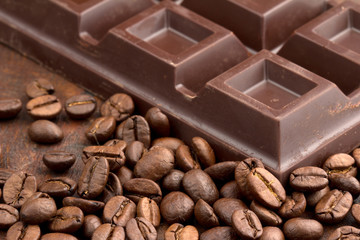 chocolate bar and coffee beans on wooden table