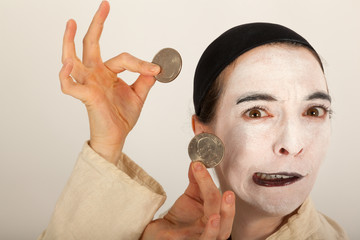 Der Clown mit einem Portmonee und Münzen in der Hand