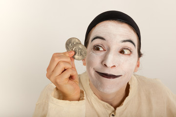 Der Clown mit einem Portmonee und Münzen in der Hand