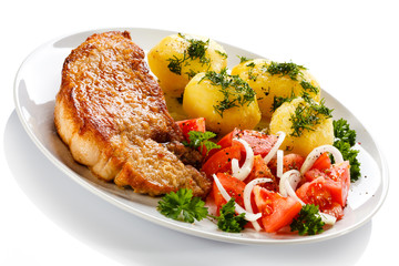 Grilled steaks, boiled potatoes and vegetable salad