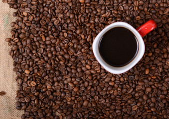 Cup of coffee on coffee beans background