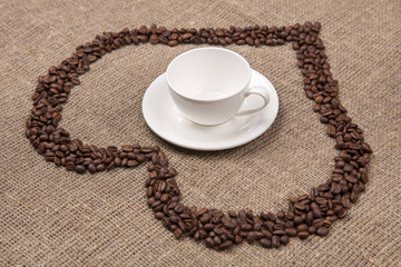 White cup of on burlap with coffee heart