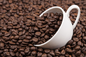 White cup with coffee beans close up