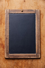 Vintage slate chalk board on wooden background