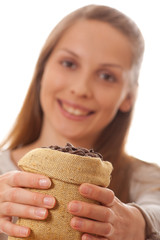 woman holding a small bag of coffee beans