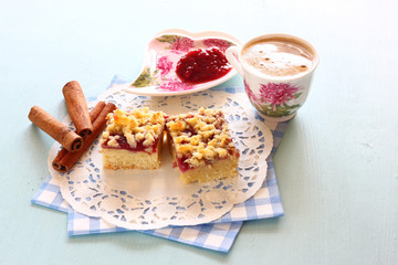 cherry cake, coffee cup and jam on wooden table