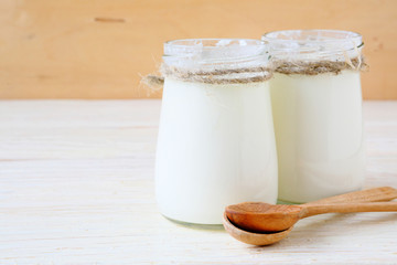 fresh yogurt in a  jars  on wooden background