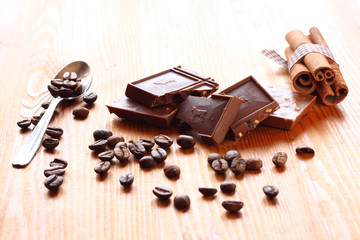 chocolate, cinamon and coffee beans on wooden table