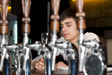 Young man seated at a bar drinking