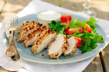 Sliced peanut crusted chicken breast with fresh salad